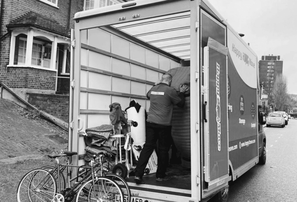 A black and white image of a removal van being loaded