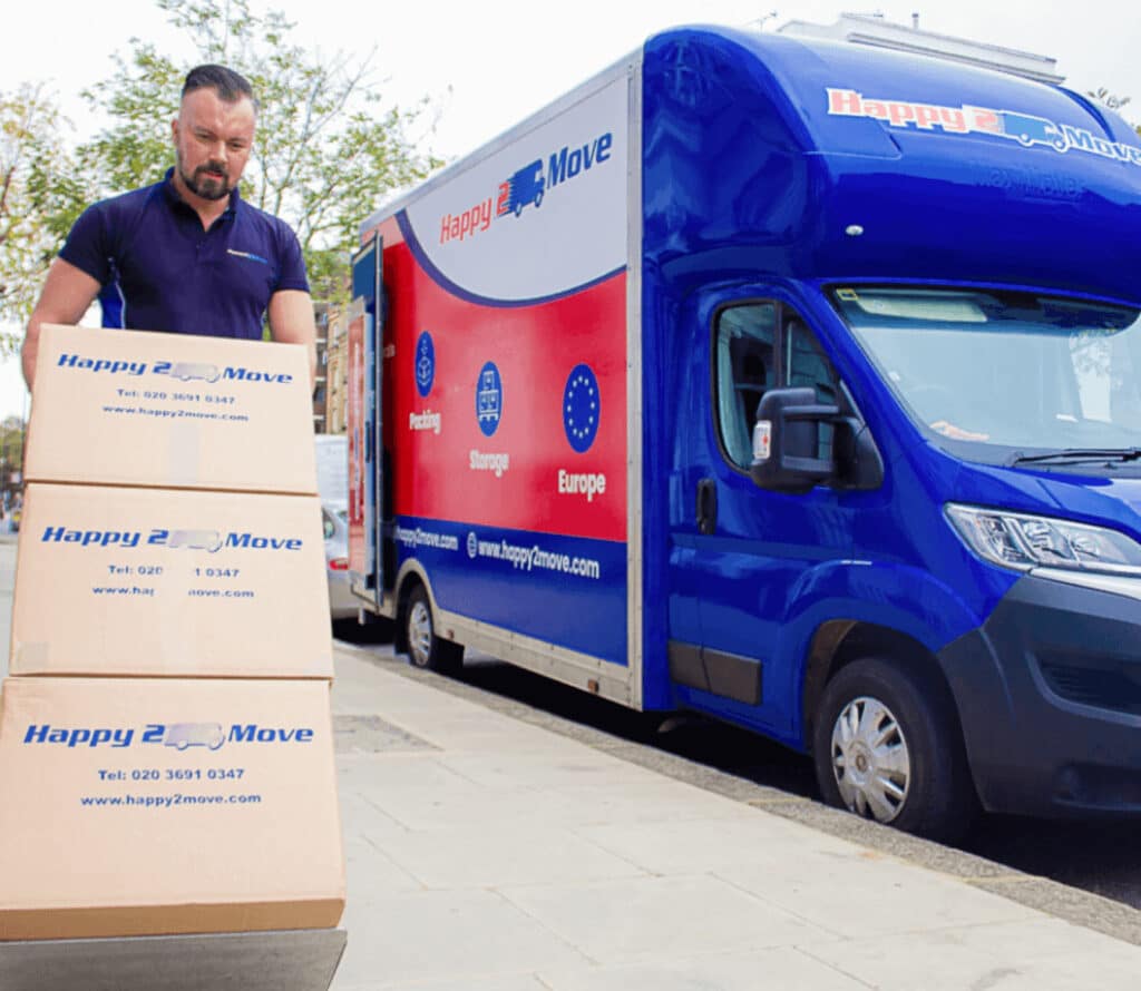 Moving man wheeling three boxes to a van